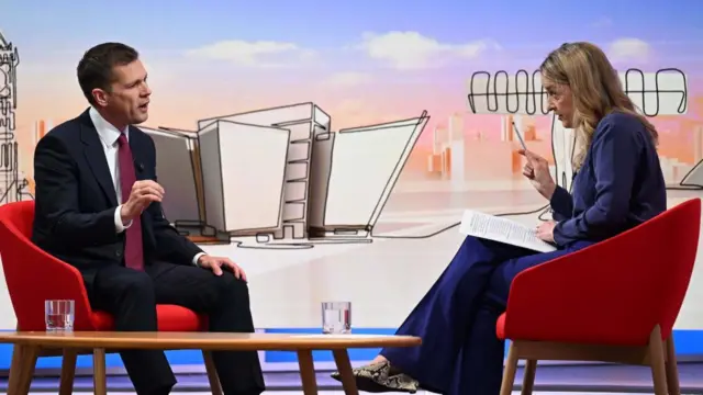 Robert Jenrick being interviewed by Laura Kuenssberg, sat opposite each other on red chairs.