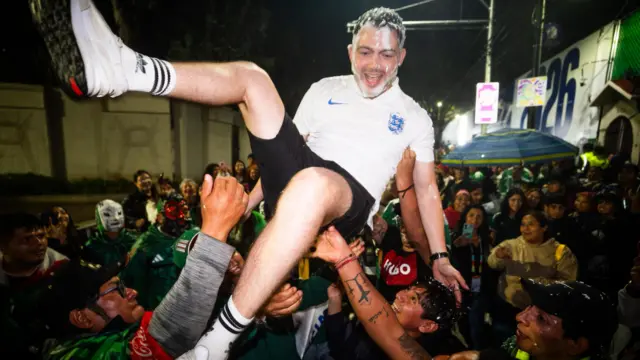 An England fan is thrown in the air outside the Mexico City stadium