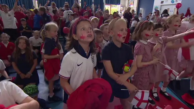 Primary school students watching as England win match against Mexico