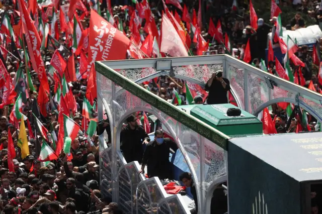 A vehicle carrying coffins of Iran's late Supreme Leader Ayatollah Ali Khamenei and his family members, makes its way as people attend a funeral procession