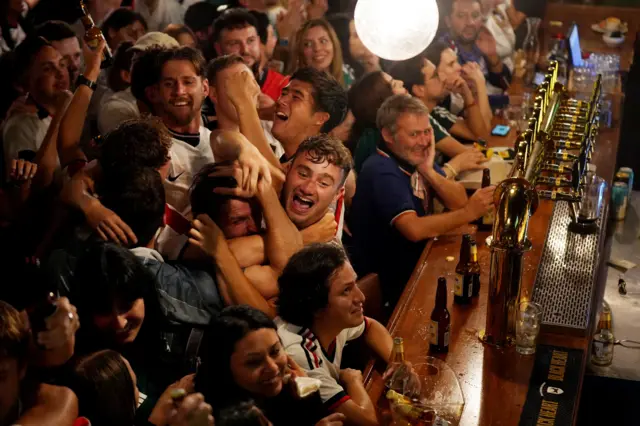A group of England fans celebrate near the bar at The Crown and Heart Pub
