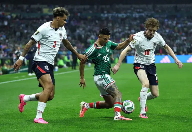 Roberto Alvarado tries to get past two defenders