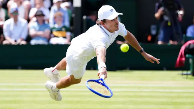 Alex de Minaur dives for a forehand