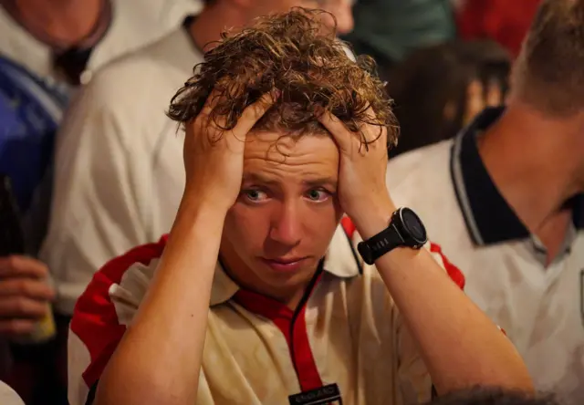An England fan with his head in his hands