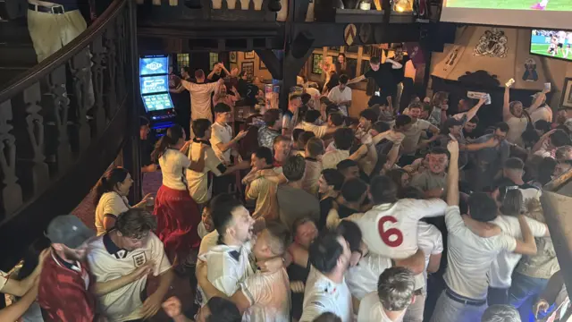 Dozens of England fans celebrate their team's goal against Mexico