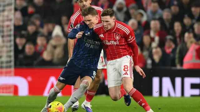 Elliot Anderson of Nottingham Forest tackles Martin Odegaard of Arsenal during the Premier League match between Nottingham Forest and Arsenal at the City Ground in Nottingham, England, on January 17, 2026
