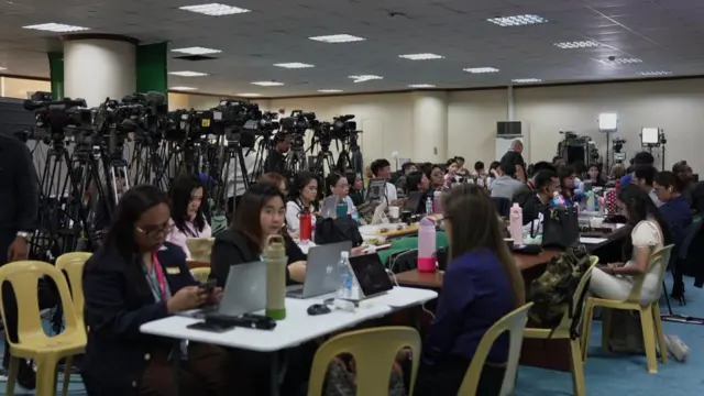 People seated at rows of tables in a room