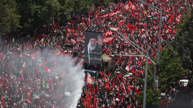 Iranians hold a portrait of the late Iranian Supreme Leader, Ayatollah Ali Khamenei, as they take part in his funeral ceremony in Tehran