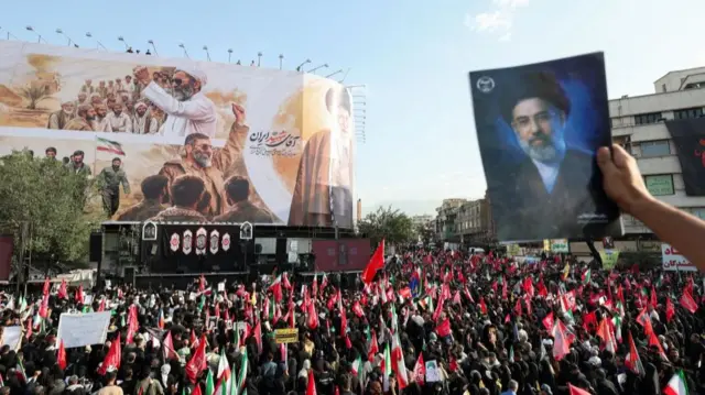 A mourner holds an image of Iran's Supreme Leader Mojtaba Khamenei as people gather for the funeral procession