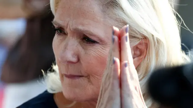 French far-right leader Marine Le Pen, member of parliament for the Rassemblement National (National Rally - RN) party, reacts during a speech delivered by Jordan Bardella, president of RN political party, in front of supporters during a country fair in Lievin, northern France, July 4, 2026.
