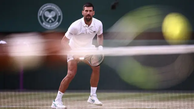 Novak Djokovic waits to receive a return