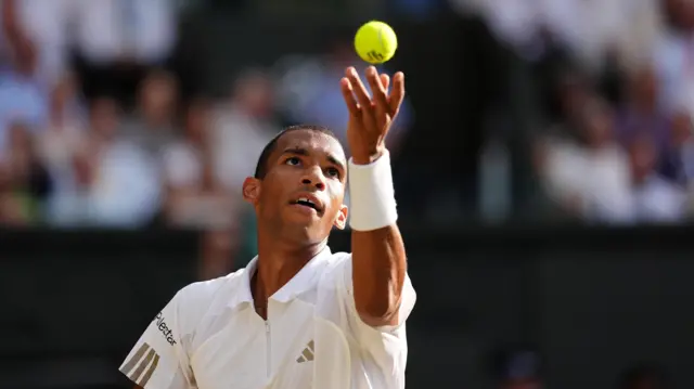 Felix Auger-Aliassime serves