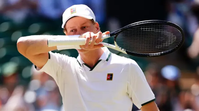 Jannik Sinner wipes his mouth