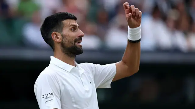 Novak Djokovic of Serbia gestures to his coaching box
