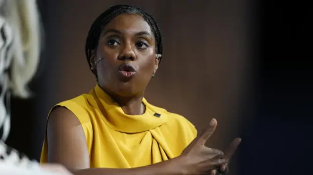 Kemi Badenoch is shown speaking at an event.