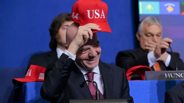 President of FIFA Gianni Infantino holds up a USA hat as he attends the inaugural meeting of the Board of Peace at the Institute of Peace on February 19, 2026 in Washington, DC. Assembled to raise money for the rebuilding and stabilization of Gaza, Trump's Board of Peace was formally established on the sidelines of World Economic Forum in January of 2026.