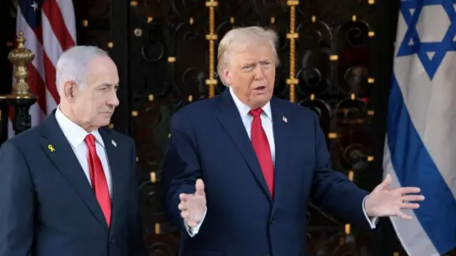Netanyahu and Trump wear navy suits and red ties and stand in front of US and Israeli flags
