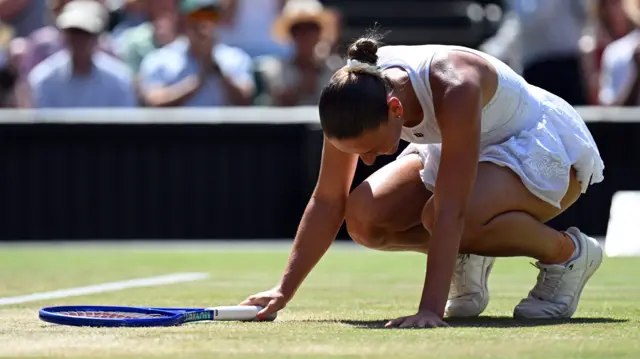 Marta Kostyuk crouches down in celebration of her victory