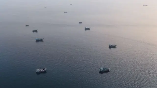 An aerial photograph of boats sitting on flat water