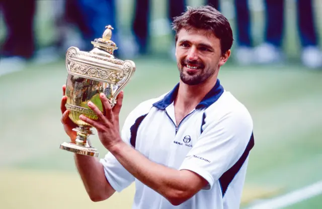 Goran Ivanisevic of Croatia lifts the winners' trophy