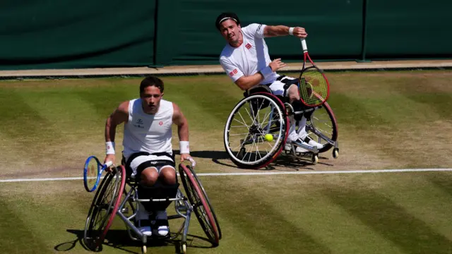 Gordon Reid serves with Alfie Hewett near the net