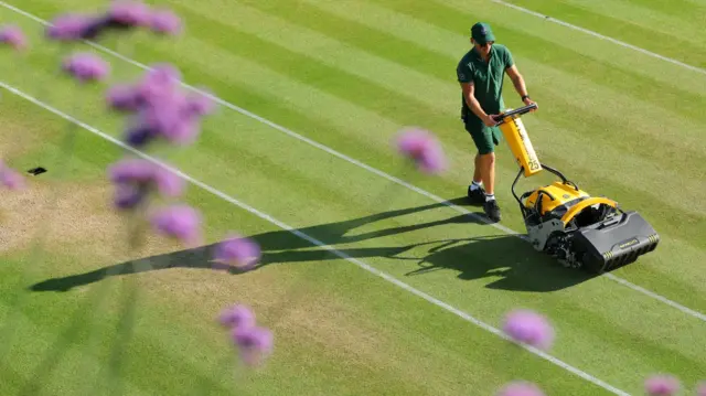 Member of Wimbledon groundstaff preparing one of the courts