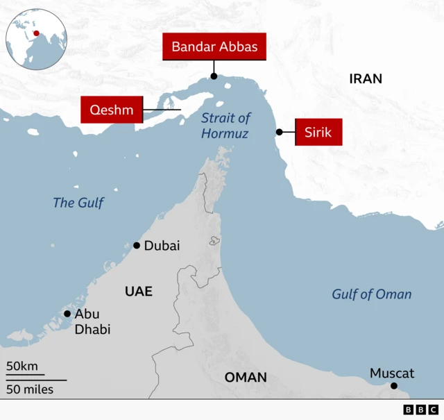 Map of southern Iran and the Strait of Hormuz highlighting three locations targeted in the latest US strikes on Iran: Bandar Abbas on the northern shore of the strait, Sirik on Iran's southeastern coast, and Qeshm island. The map also shows the UAE and Oman - Iran's neighbours to the south - and labels the cities of Dubai, Abu Dhabi and Muscat.