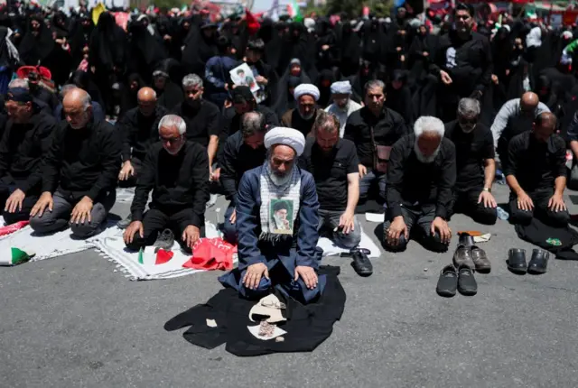 People praying on their knees in Mashhad