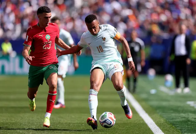 Mbappe holds off a defender as he runs down the wing