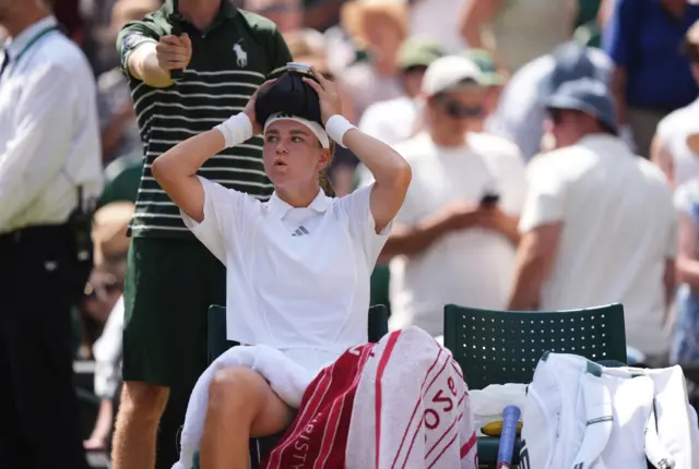 Muchova holds an ice pack to her head
