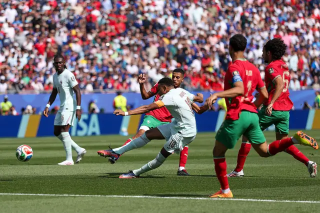 Mbappe shoots as he is surrounded by Morocco players