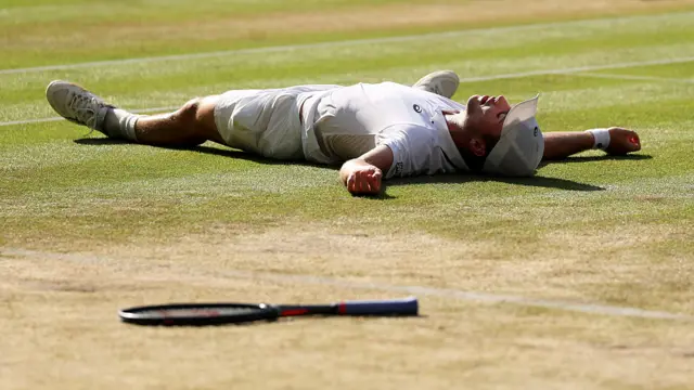 Arthur Fery lies on the grass on Wimbledon Centre Court