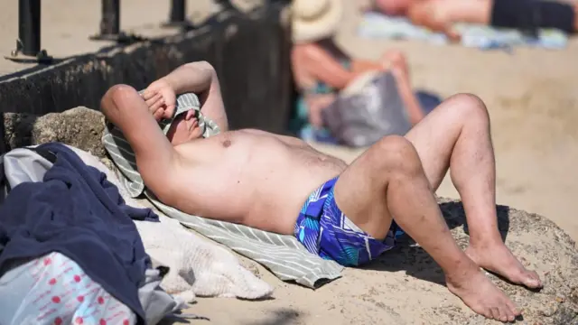 A man sunbathes on a beach