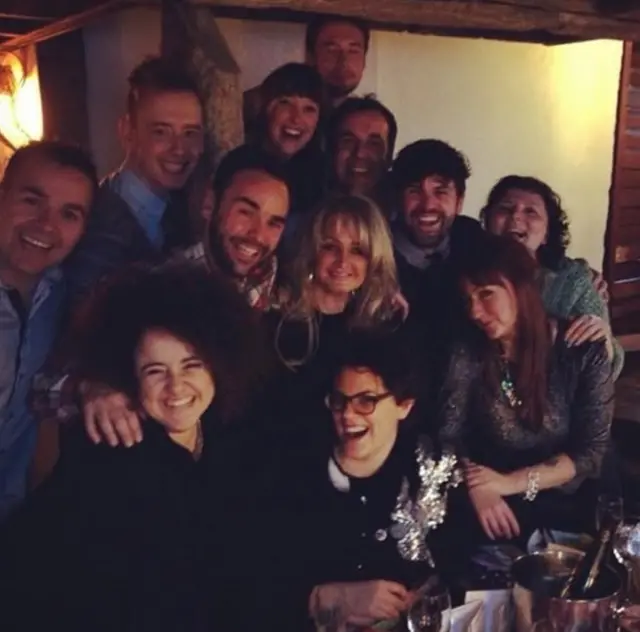A group of people along with Bonnie Tyler posing for a photo. All are smiling.