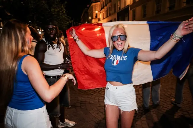 A supporter agitates a French flag during the celebrations