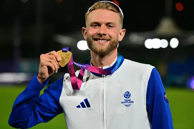Scotland's Josh Kerr poses with his gold medal after the men's one mile final