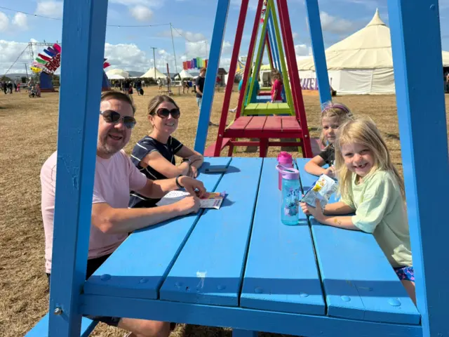 Mae'r teulu yma o Gaerdydd yn mwynhau diwrnod cyntaf y Brifwyl