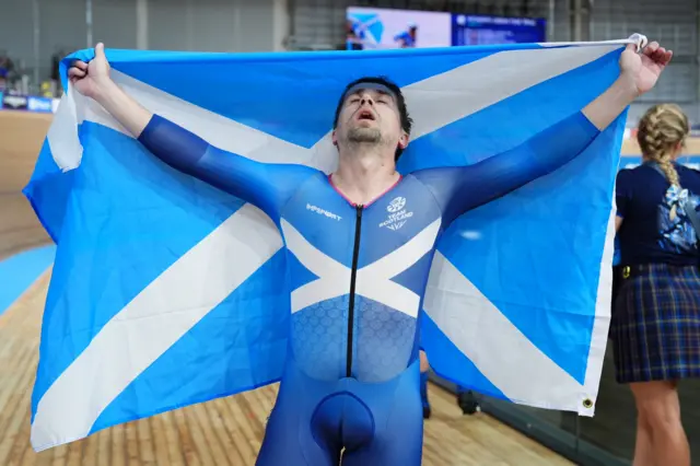 Neil Fachie holds up the Scotland flag