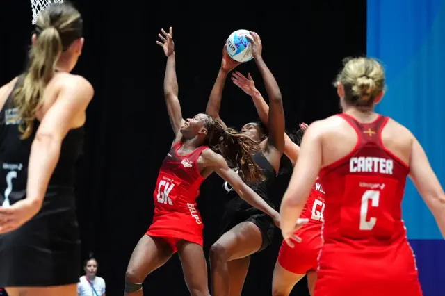 Grace Nweke grabs the ball under heavy pressure from England players