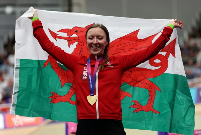 Gold medalist Anna Morris of Team Wales poses with her flag on the podium during the Women's 4000M