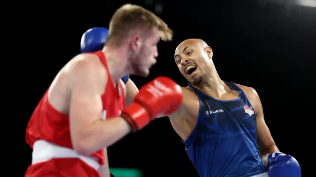 Isaac Okoh, wearing England's blue jersey, fights against Wales' Connor Williams