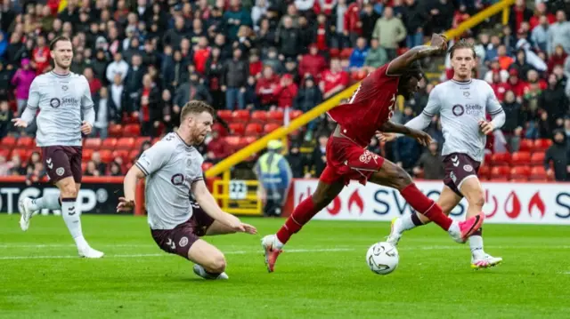 Hearts' Stuart Findlay fouls Toyosi Olusanya