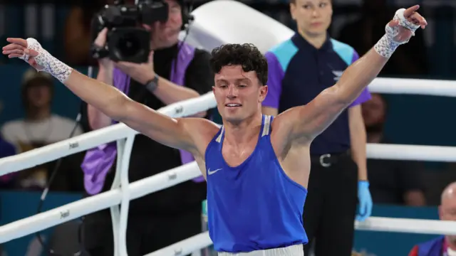 Jon McConnell celebrates after winning gold with his hands in the air