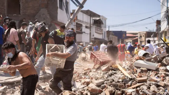 Residents dig through the debris of a collapsed building after an earthquake, in Cali, Colombia August 10, 2026