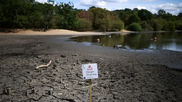 The dried and cracked bed of the depleted Hollow Pond and Leyton flats near Wanstead, east London, on August 10, 2026