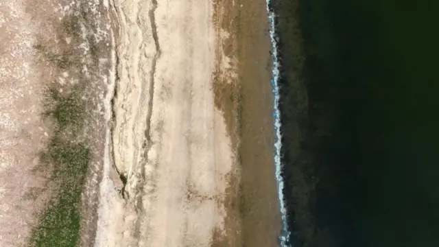 Dry arid ground seen next to a water line