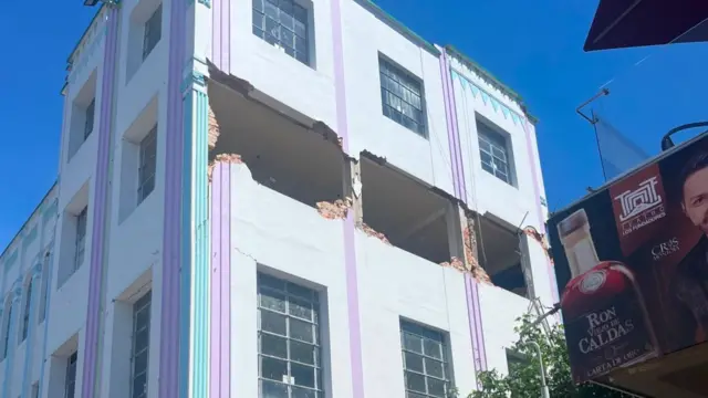 A building with three large holes in the side of it where bricks have fallen out following the quake