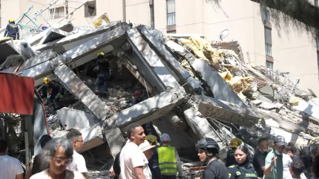 People survey the rubble of a building that collapsed following a 7.4-magnitude earthquake in Cali, Colombia, 10 August 2026