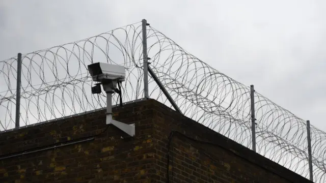 A camera on the corner of prison railings