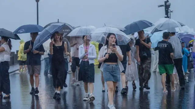 A group of tourists carrying transparent umbrellas under the rain in China